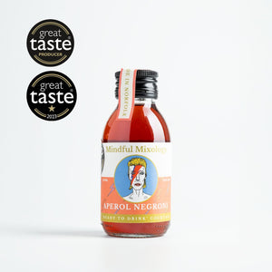 In the centre of the page is a single-serve cocktail in a cute looking small glass bottle, with a black aluminium cap. To the left of the page are some award logos from the Great Taste awards; one star in 2023 and a logo for a Great Taste producer. The cocktail is an Aperol Negroni and the label is orange and white. In the centre is a circle and a picture which looks like David Bowie as Ziggy Stardust in the centre, with a blue background. The cocktail is a deep orange/red colour.