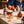 Load image into Gallery viewer, There are some cocktails on a table, with a tablecloth and a vase of dried flowers. It&#39;s an espresso martini. A lady is in the background drinking an aperol negroni, but is out of shot. Lots of Mindful Mixology mini cocktails are on the table, with some dried orange slices.
